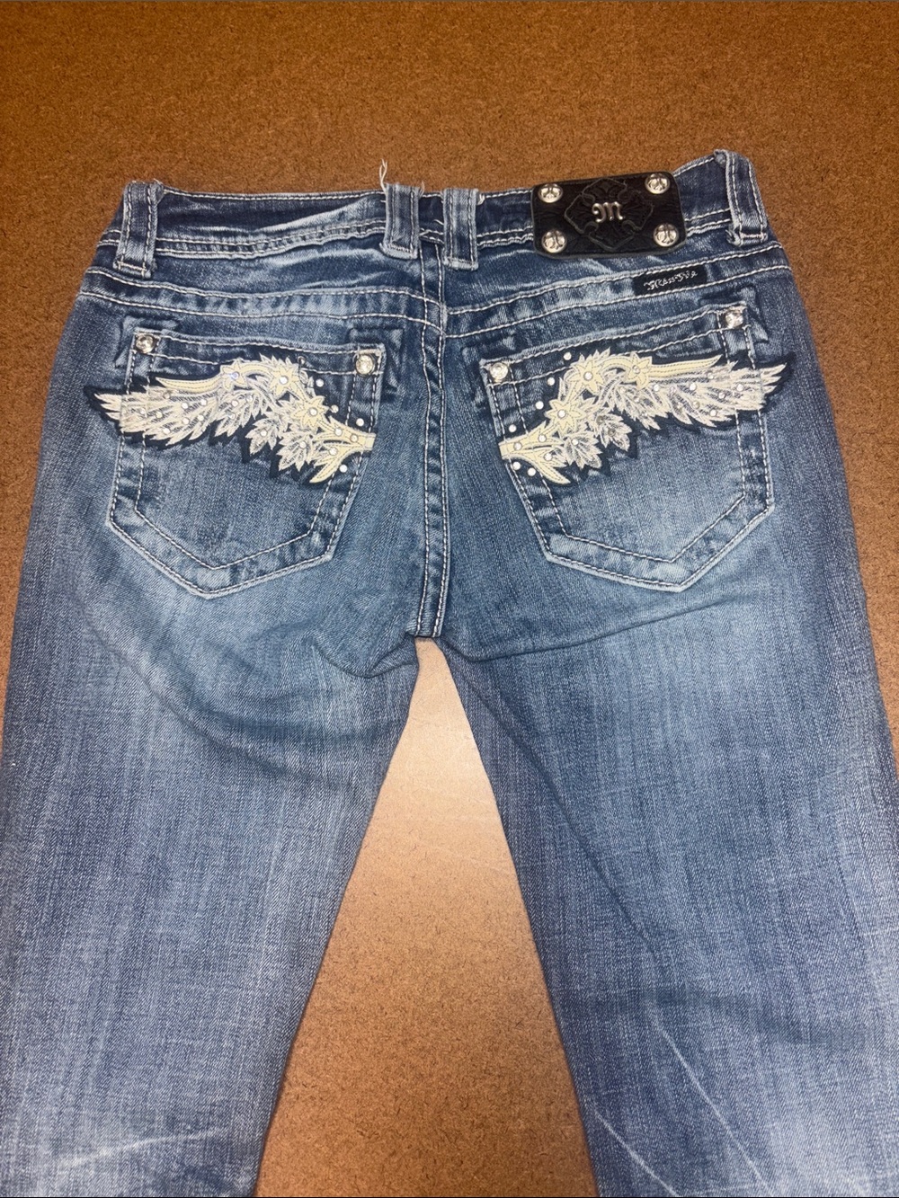 Miss Me 27x34 Blue Distressed Bootcut Jeans with Cream Wing Embroidery